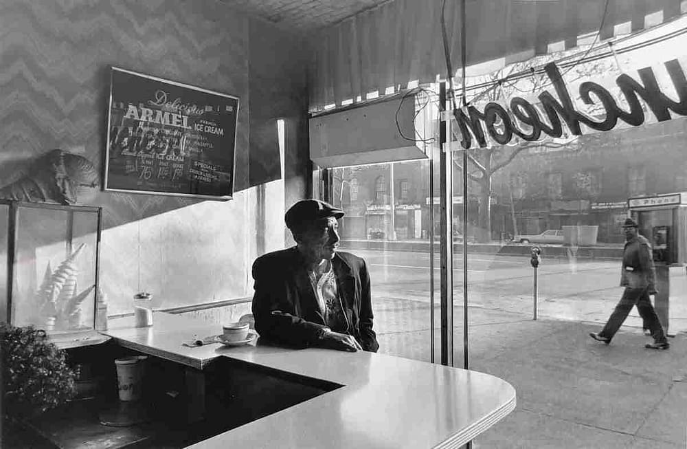 Photograph of a man sitting in a coffee store by by Chester Higgins is one of the images celebrating New York City at the Amory Show