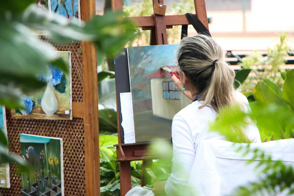 woman painting outside garden. It is important to stay safe when practicing Your Outdoor Art