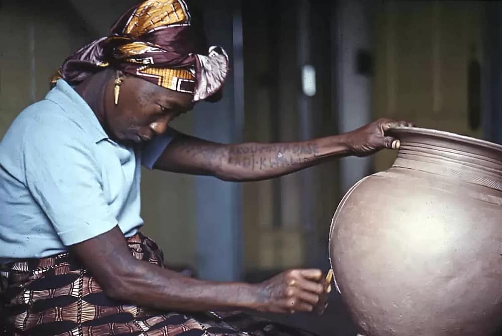 Ladi Dosei Kwali at work decorating a pot. Her work inspired other Black women ceramic artists ho use clay to address topical issues.