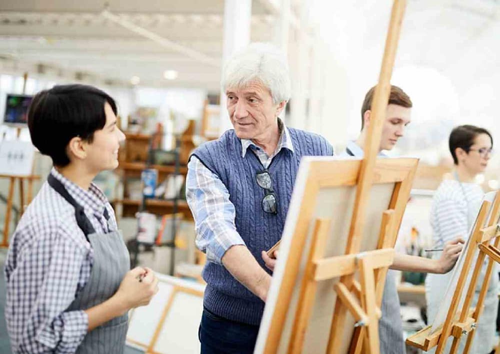 Art instructor working with young artists, teaching them the best habits artists should have to become better