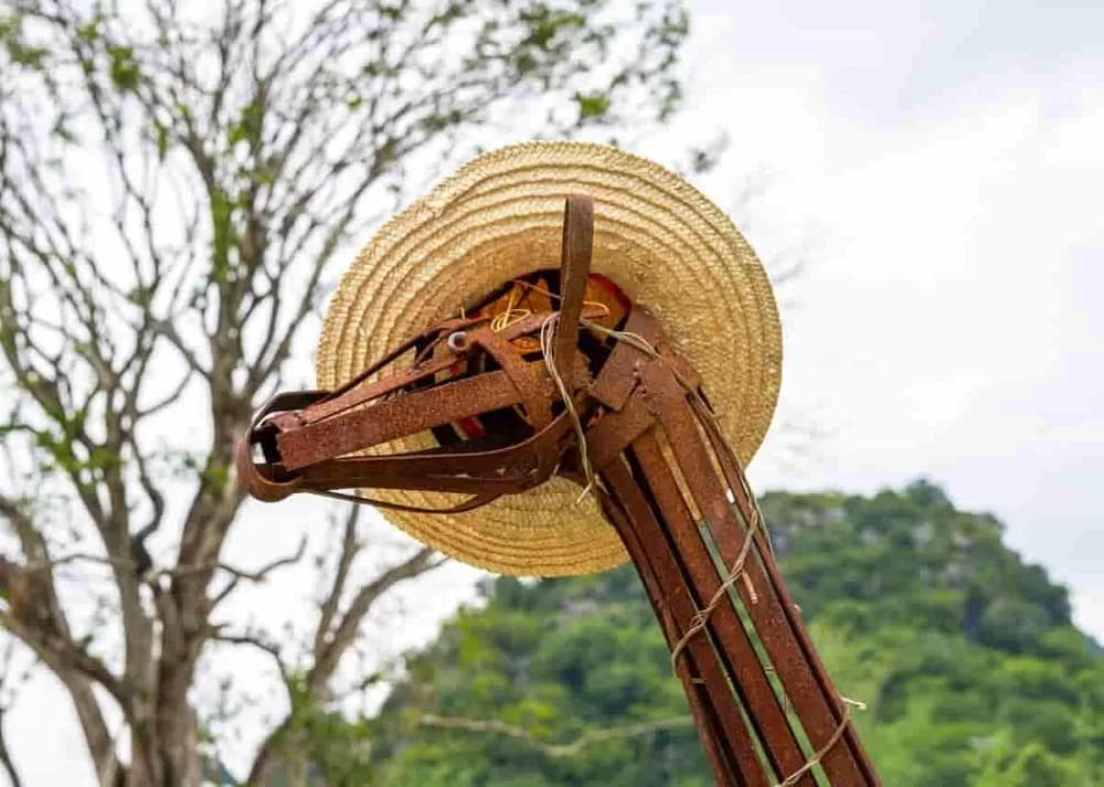 Outdoor metal yard art made of scrap metal wearing a hat