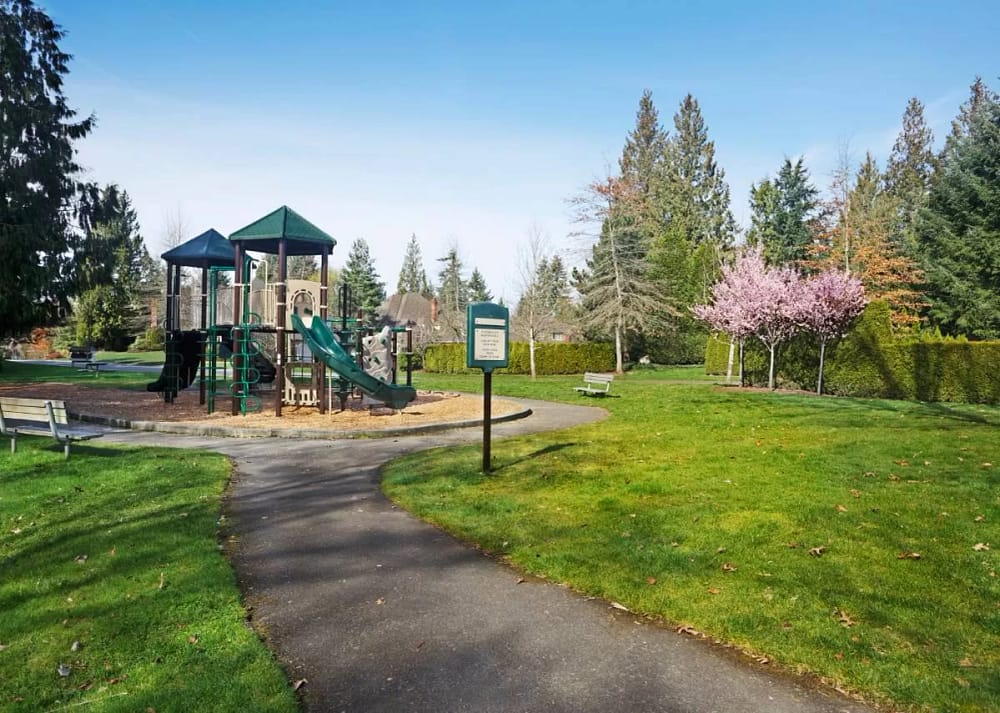 A small community park with updated play equipment, a clean sidewalk, and freshly cut grass. It's a sunny day outside. Simple improvements for community parks can make a huge difference.