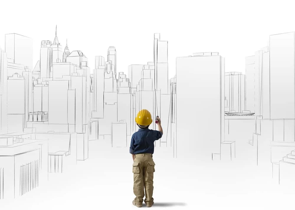 A child in a blue shirt, cargo pants, and yellow hard hat holds a marker and stands in front of a sketch of a city skyline. Engagement is one of the strategies to use art & architecture to inspire kids’ creativity