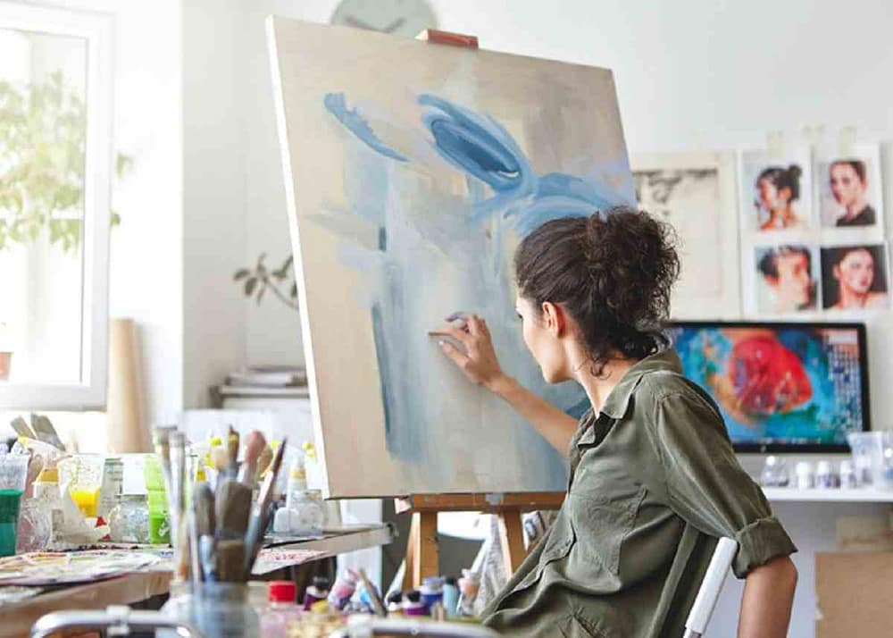 A painter at work in her studio painting and trying to figure out how to become a professional artist in 2022
