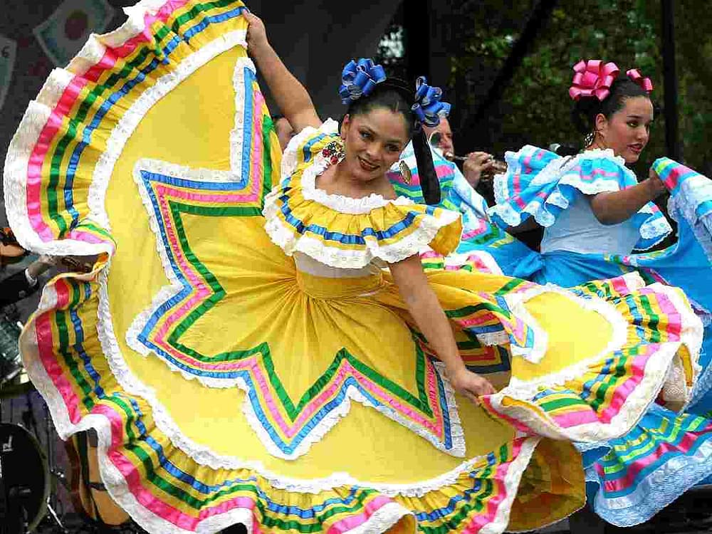 Dances dressed in colorful dresses celebrating Cinco de Mayo. This