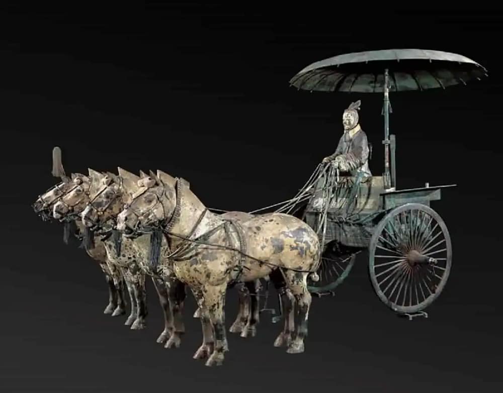 Ancient Chinese bronze statue of a chariot with four horses and a rider, showcasing traditional craftsmanship.