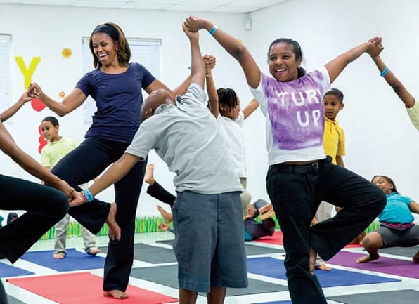 During a yoga class for after school activities, First Lady Michelle Obama joins children at Gwen Cherry Park in Miami, Florida during a Let’s Move! program