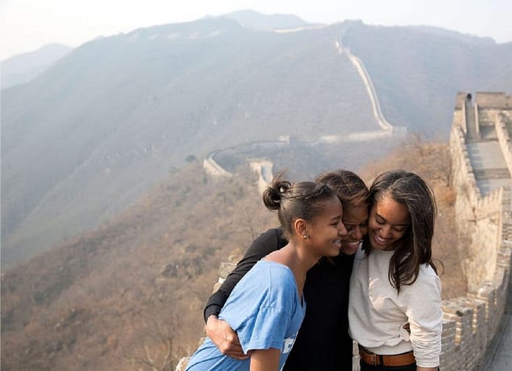 In a show of motherly love, Mrs. Obama hugs her daughters atop the strikingly empty Great Wall of China