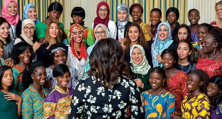 Standing in front of cheering students from Morocco and Liberia in the State Dining Room, the First Lady welcomes her young guests to the White House