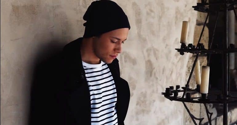 New York singer-songwriter Joel Phil in front of a candle in a video debuting 'Perdóname', his second consecutive single for 2019