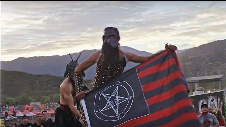 Image: A member of American Satan wearing gas mask waves the devils flag in the movie American Satan by Ash Avildsen-Entertainment news
