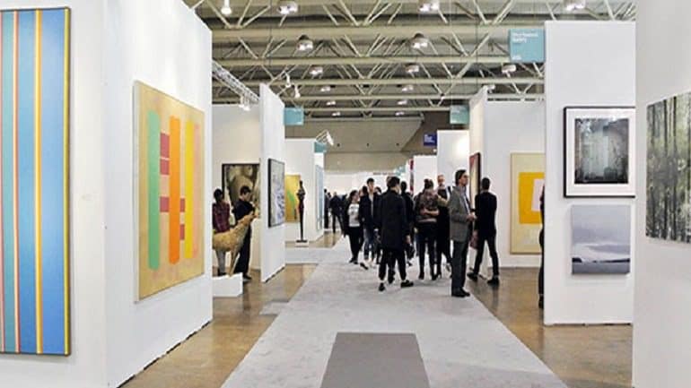 Image: Visitors and guests a recent Art Toronto examining works on display at Canada’s international contemporary and modern art fair. Art Toronto 2018 is expected to attract more art lovers