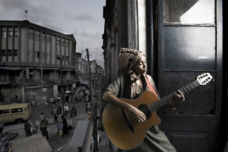 Image- Musician- Nigerian girl playing a guitar is an example of contemporary art photography 