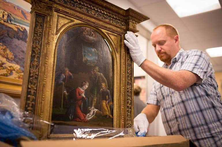 Image - Nativity- Chris Rupp, Westmont Museum collections manager, uncrating the Tisi painting, a recent addition to the Westmont Ridley-Tree Museum of Art collection