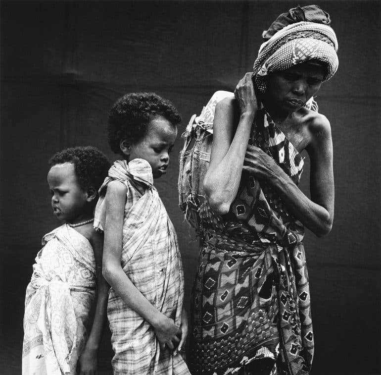 Image: It shows a Somali Refugee Family made up of three children. It shows the consequences of war and natural desaters. It was taken by Gedda, a professional photographer who captures intimate emotions